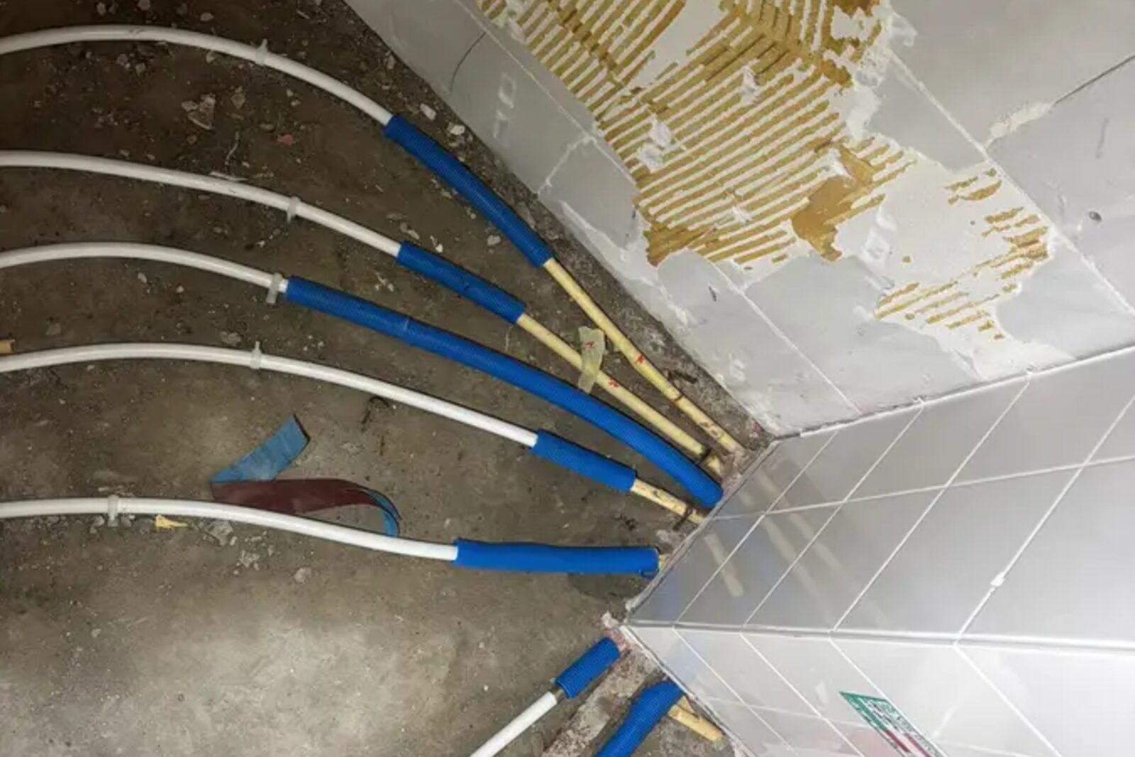 Leidingen van vloerverwarming en waterleiding in een vloer