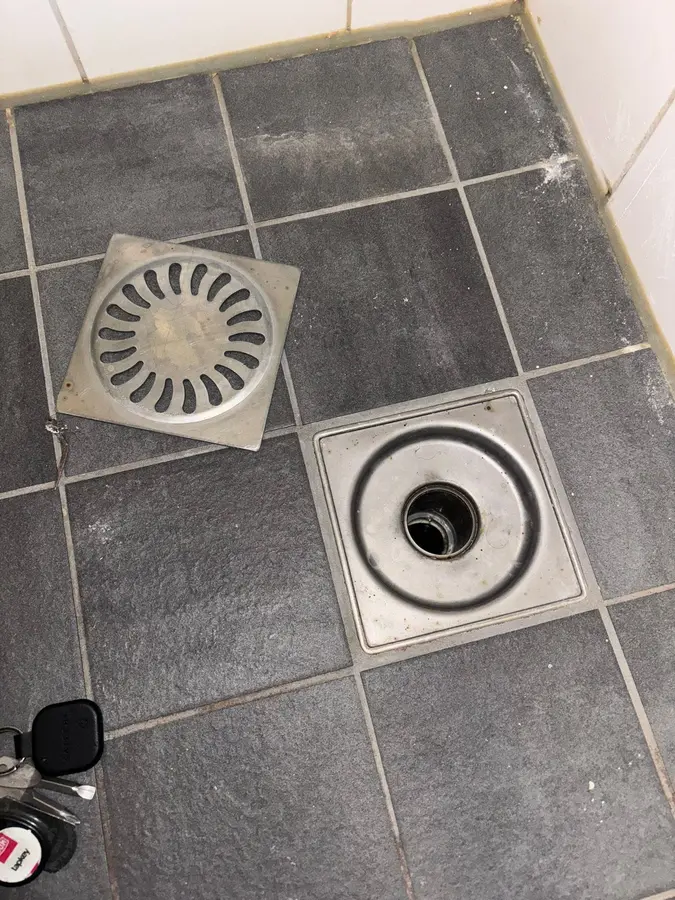 Ontstopping & riool — Vloerput en afvoerputje in een tegelvloer