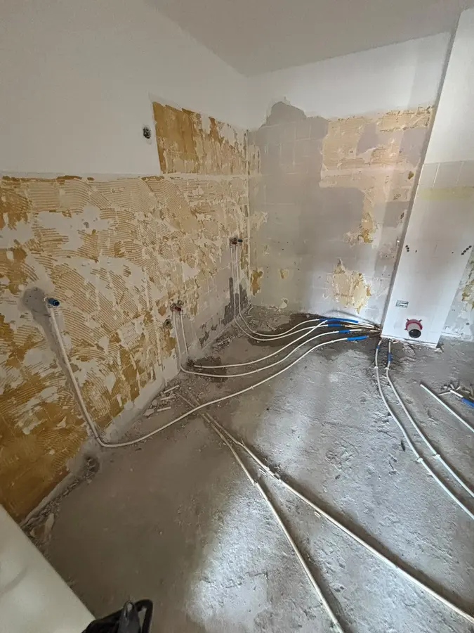 Waterleiding — Gestripte badkamer met nieuw aangelegde leidingen in de vloer