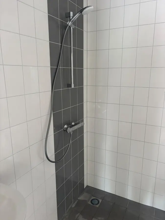 Badkamerrenovatie — Betegelde douchehoek met glijstang en afvoer in de vloer