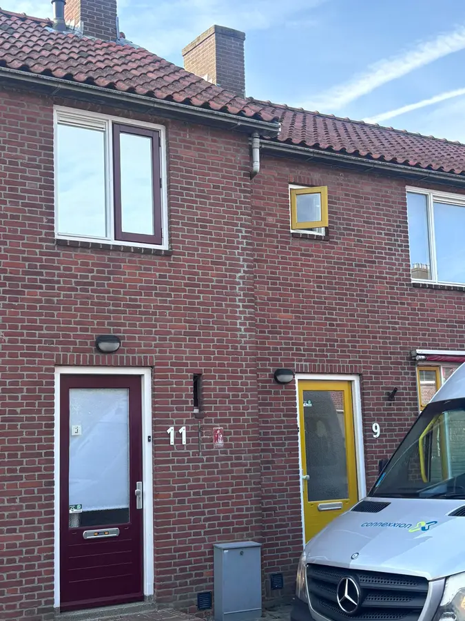 Onderweg naar een klus — Woning waar gewerkt wordt, met de bedrijfsbus voor de deur