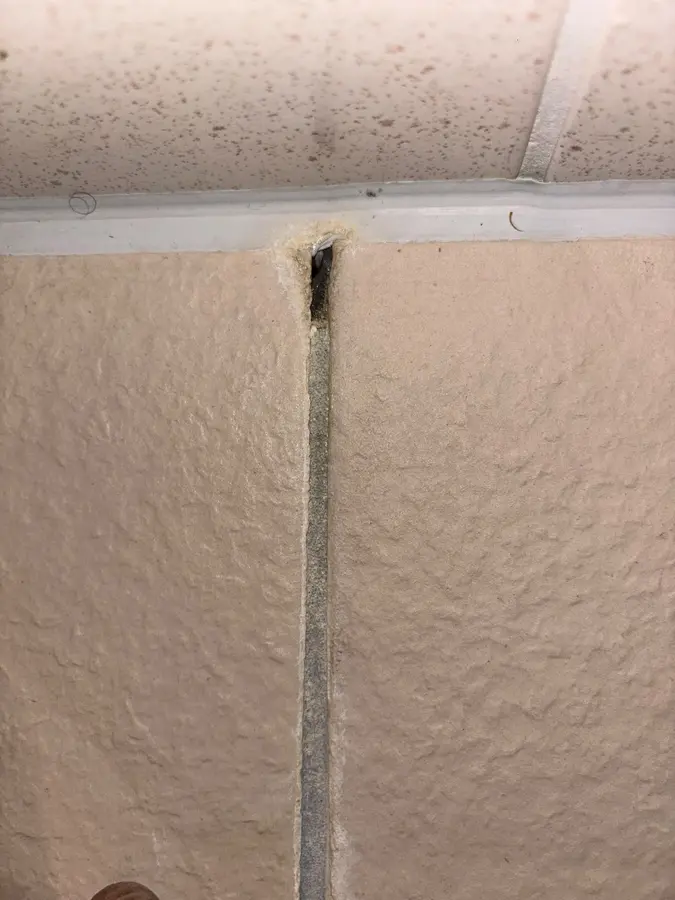 Waterleiding — Verticale opbouwleiding langs een geverfde structuurwand