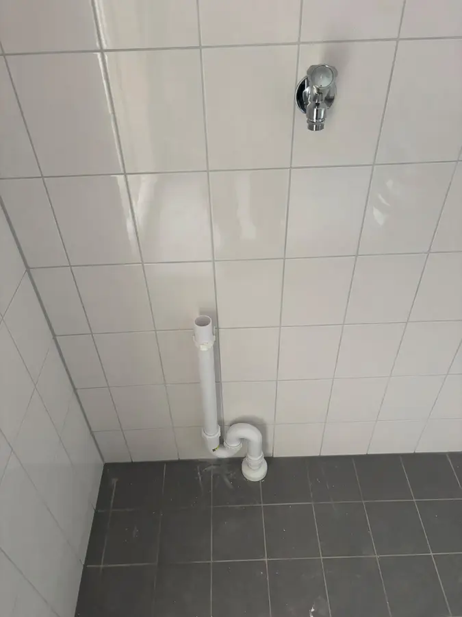Badkamerrenovatie — Doucheruimte met wandaansluiting en afvoer, na demontage van de kraan