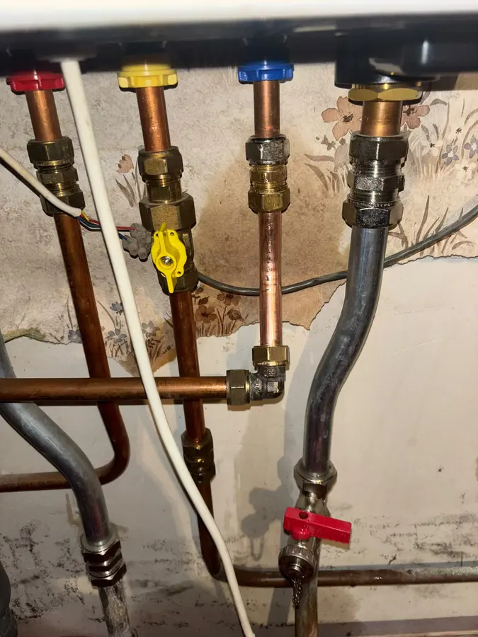 CV & verwarming — Koperen leidingen met afsluiters en gasleiding onder een cv-ketel