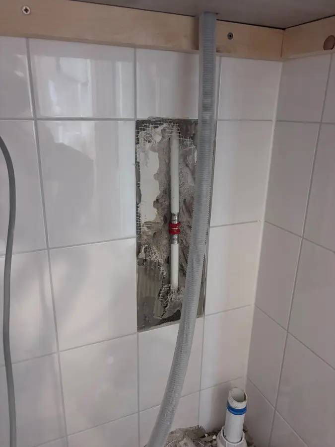 Lekdetectie — Uitgehakte sleuf in een betegelde wand voor een nieuwe leiding