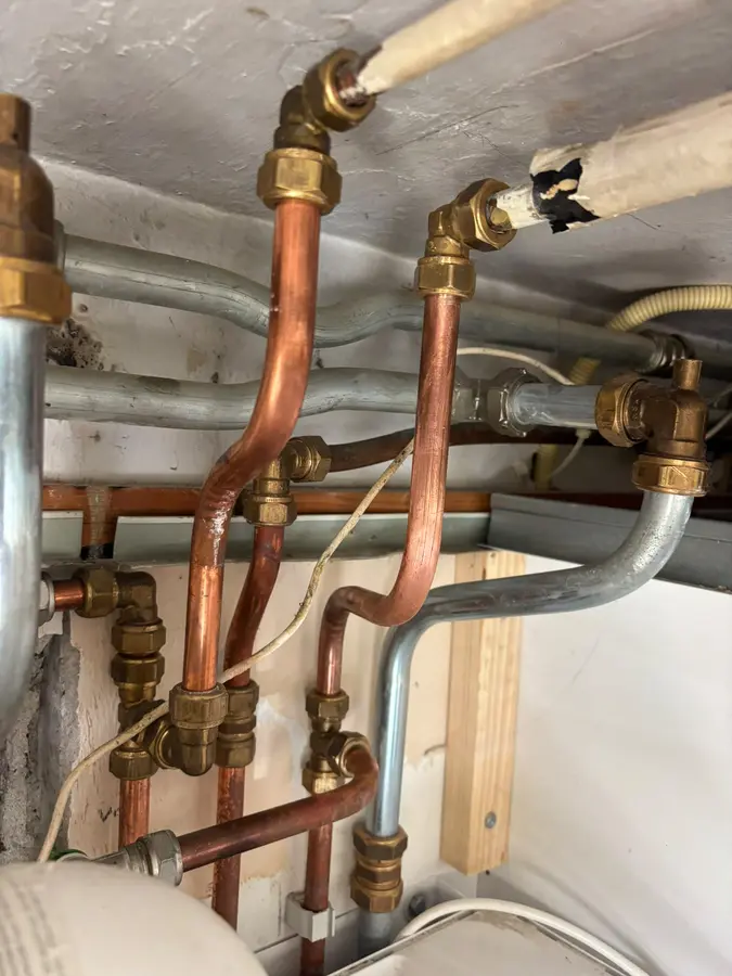 CV & verwarming — Koperen cv-leidingen met koppelingen boven een installatie