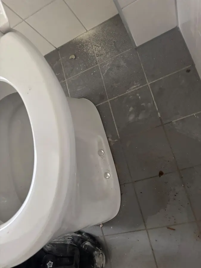 Sanitair & kranen — Losgenomen toiletpot op een betegelde vloer