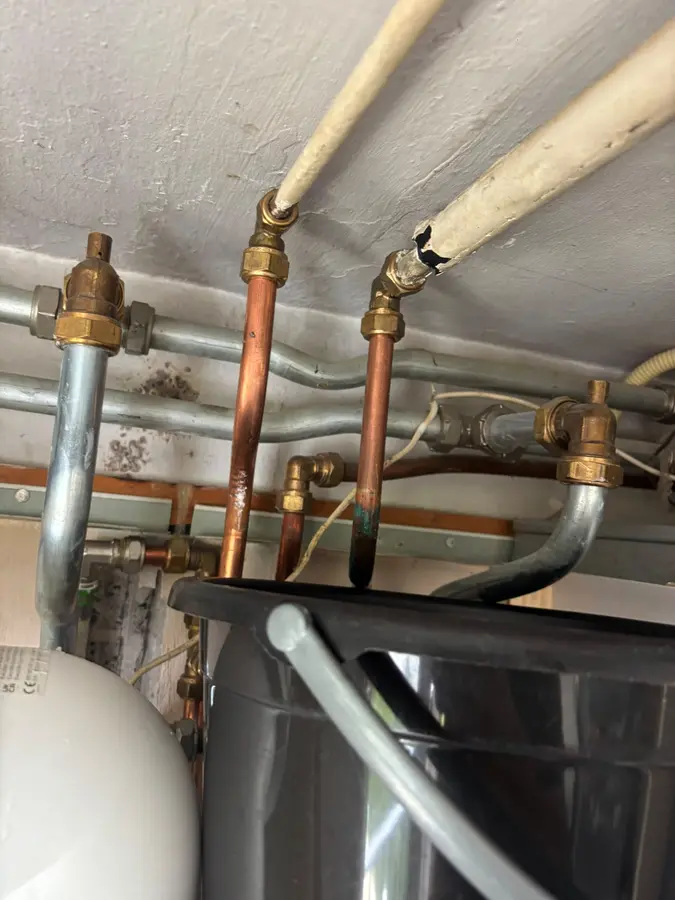 CV & verwarming — Koperen leidingen met afsluiters boven een boilerinstallatie